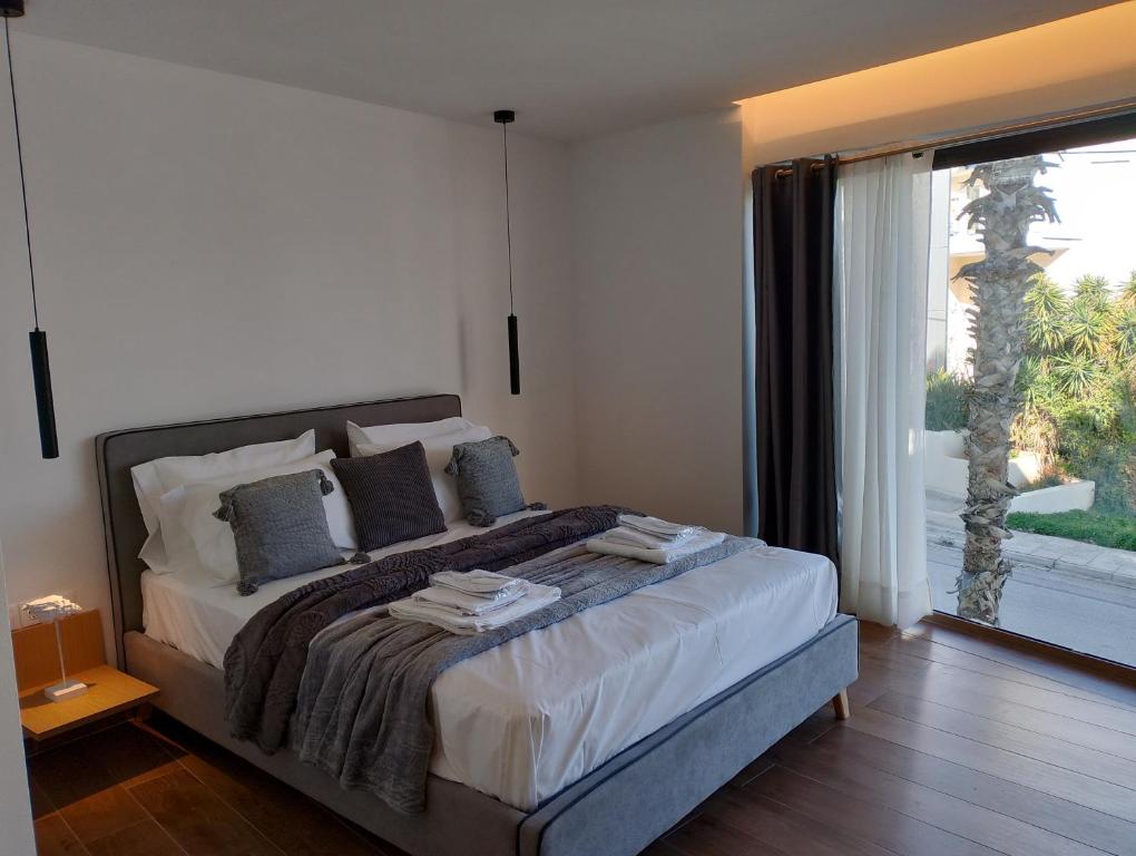a bedroom with a bed and a large window at Rafina Studio apartments kondilia in Rafina