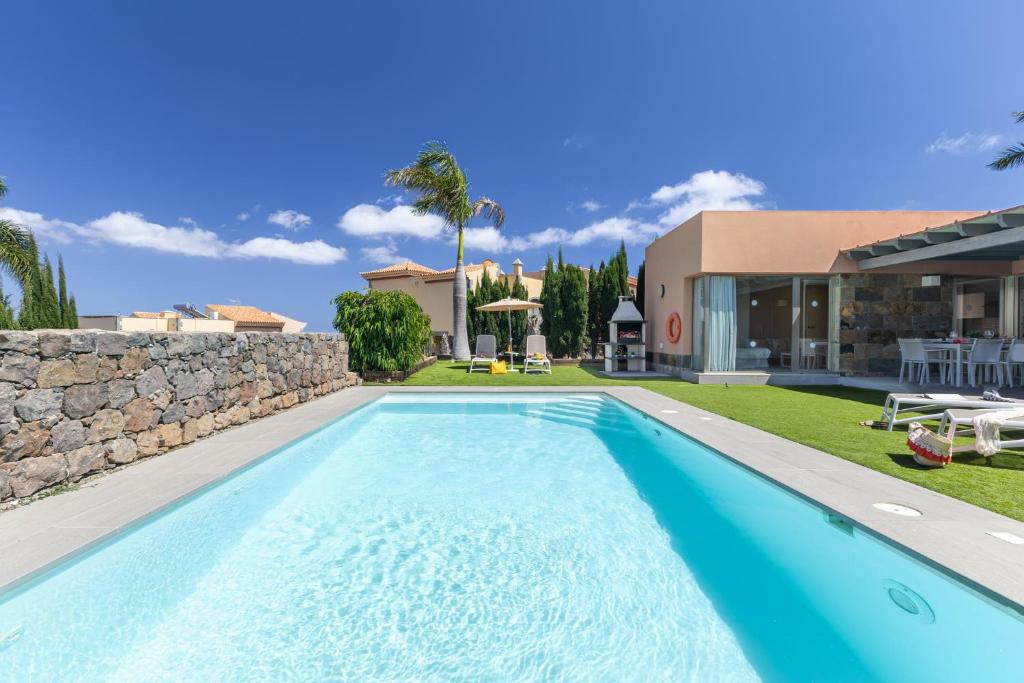 a swimming pool in the backyard of a house at Yellow Sunshine 8 by VillaGranCanaria in Salobre