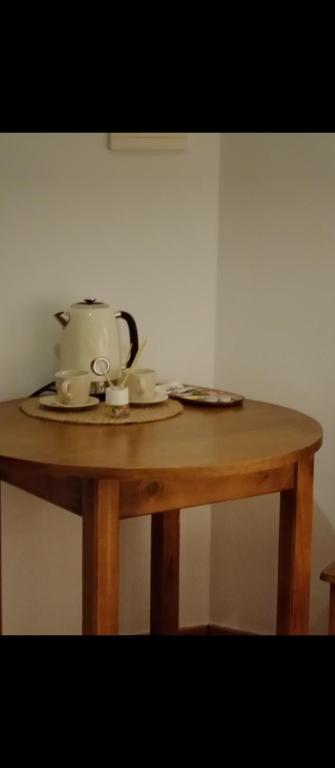 a tea pot and cups on a wooden table at El rincón del Vadillo in La Velilla