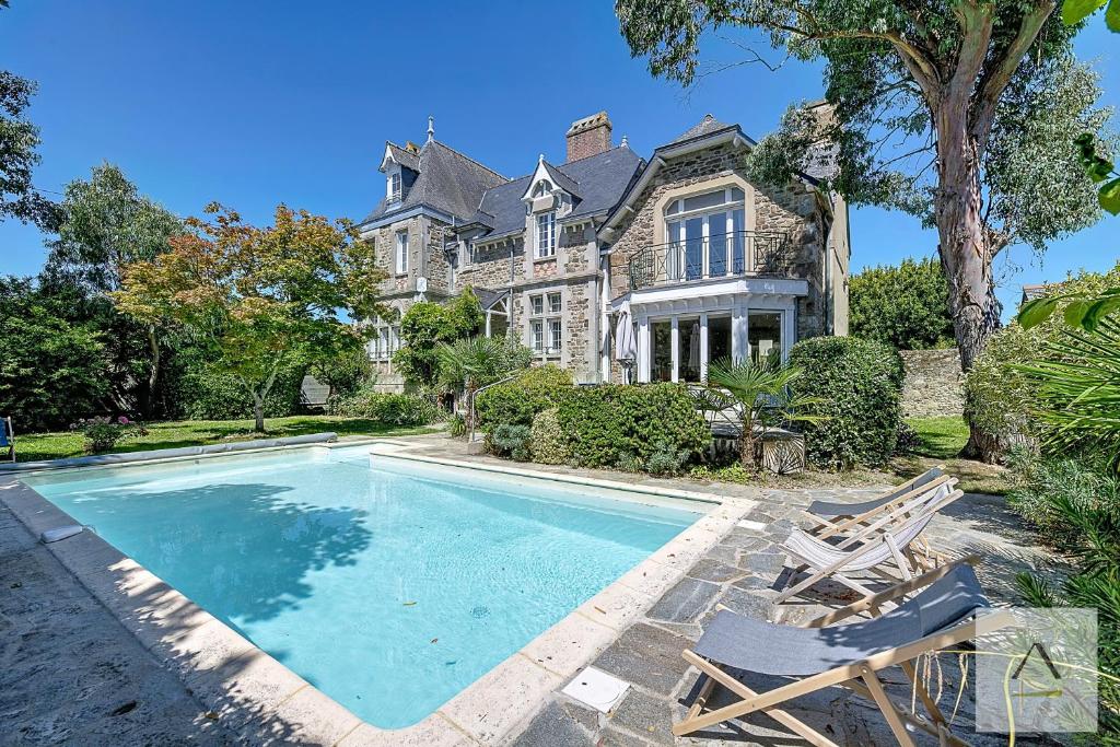 an estate with a swimming pool in front of a house at La Villa Moorings in Saint Malo