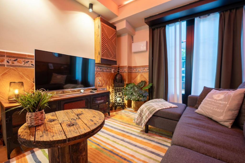 a living room with a couch and a tv and a table at Acogedor Apartamento Loft in Fuenlabrada