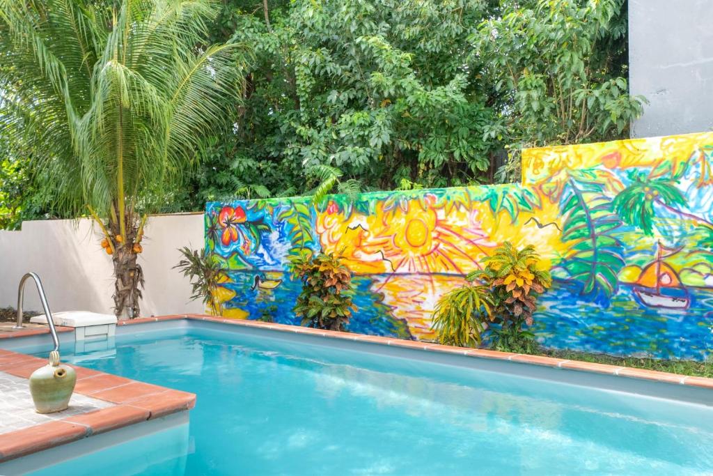 a swimming pool with a colorful tile wall next to a swimming pool at Villa Kaz a Ramon in Port-Louis