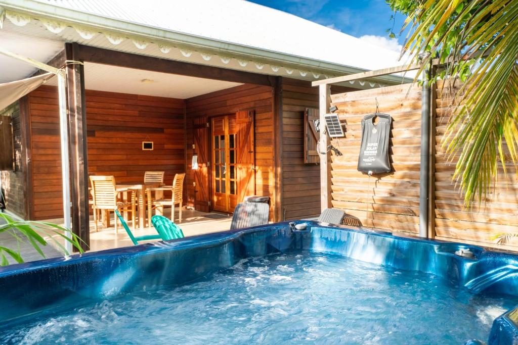 a swimming pool in front of a house at Bungalow Kaz Graj in Sainte-Anne