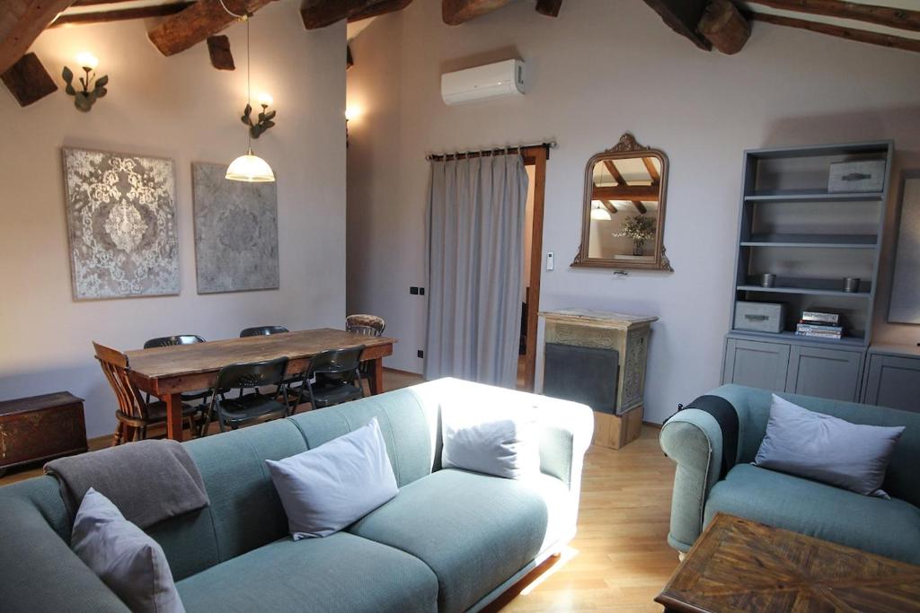 a living room with a blue couch and a table at Guest House Dell'Affresco in Reggio Emilia