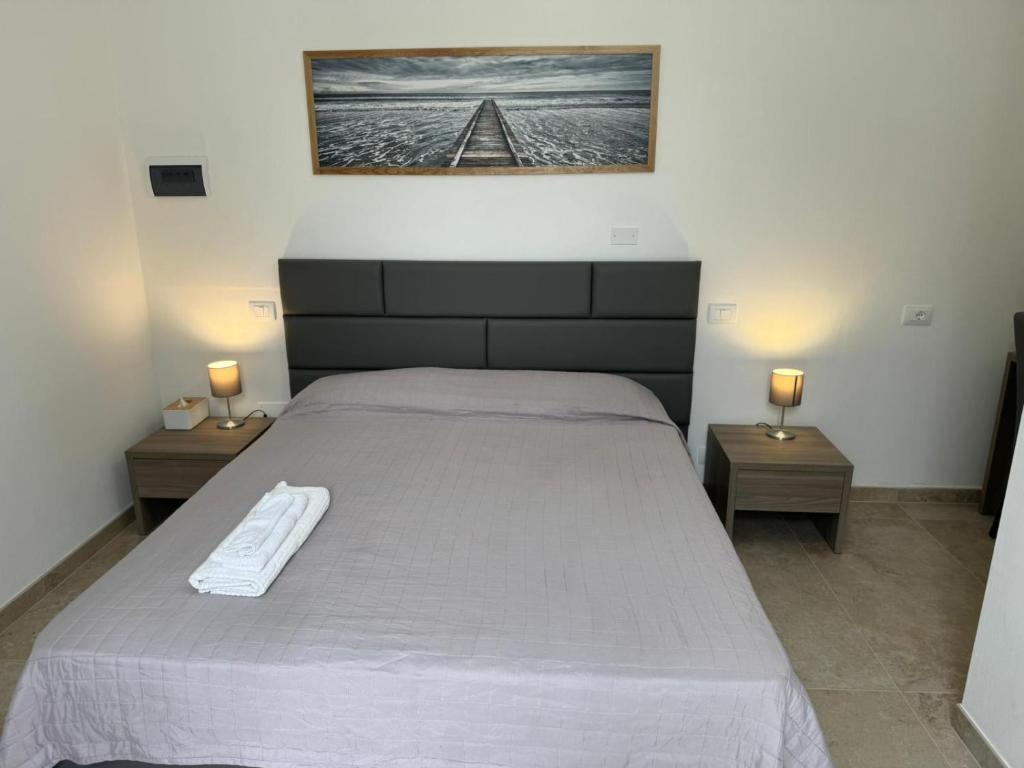 ein Schlafzimmer mit einem großen Bett und zwei Nachttischen in der Unterkunft Isamar in Grosseto