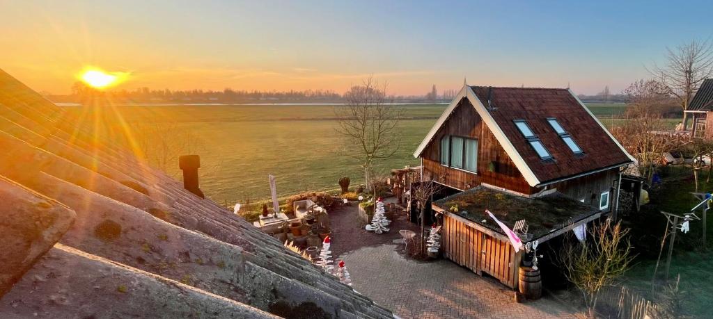 an aerial view of a log cabin with the sunset in the background at De Bommelerhoeve B&B & Vakantiewoning Dirkje in Poederoijen