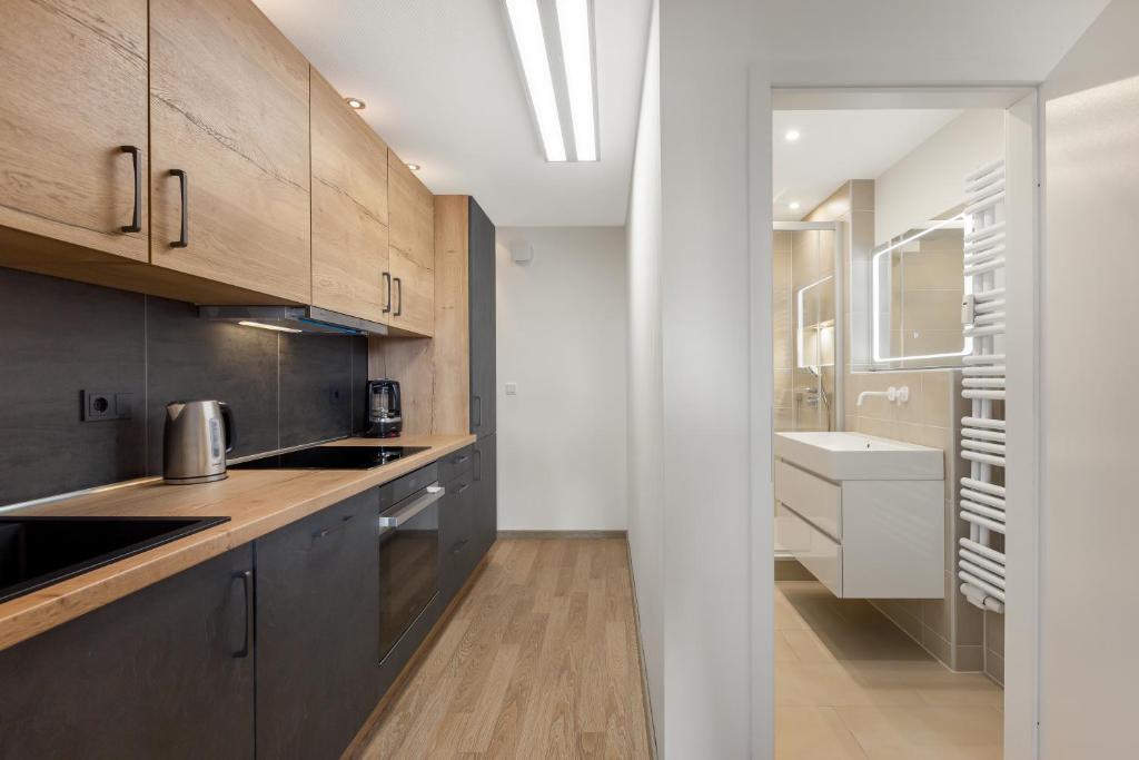 a kitchen with wooden cabinets and a sink and a counter at Ferienwohnung Bernhard in Wermelskirchen
