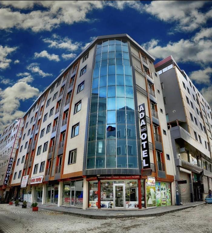 a large building with glass windows on a street at Ada Mevan Otel in Ipekyolu