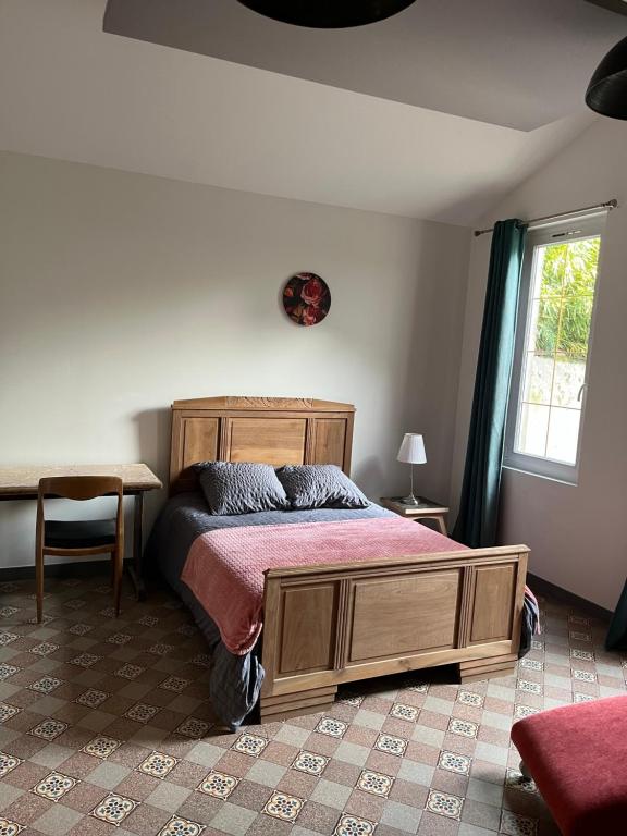 a bedroom with a bed and a window at La Berge in La Flocellière