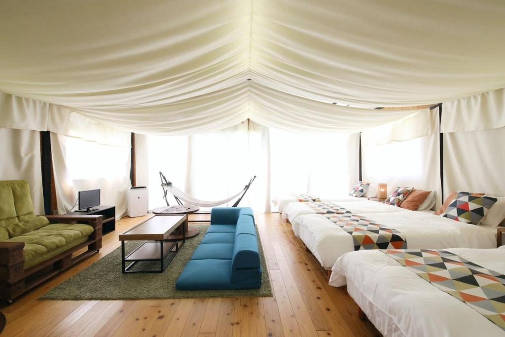 a large room with four beds and a couch at halfGlamping星音 B in Nakijin
