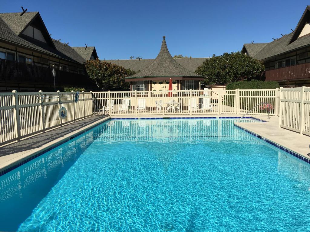 a swimming pool with a white fence and blue water at Pea Soup Andersen's Inn in Buellton