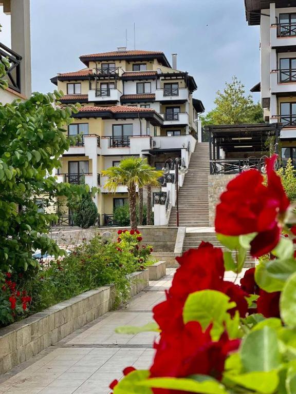 a large building with stairs and flowers in front of it at Апартаменти Литорал in Chernomorets