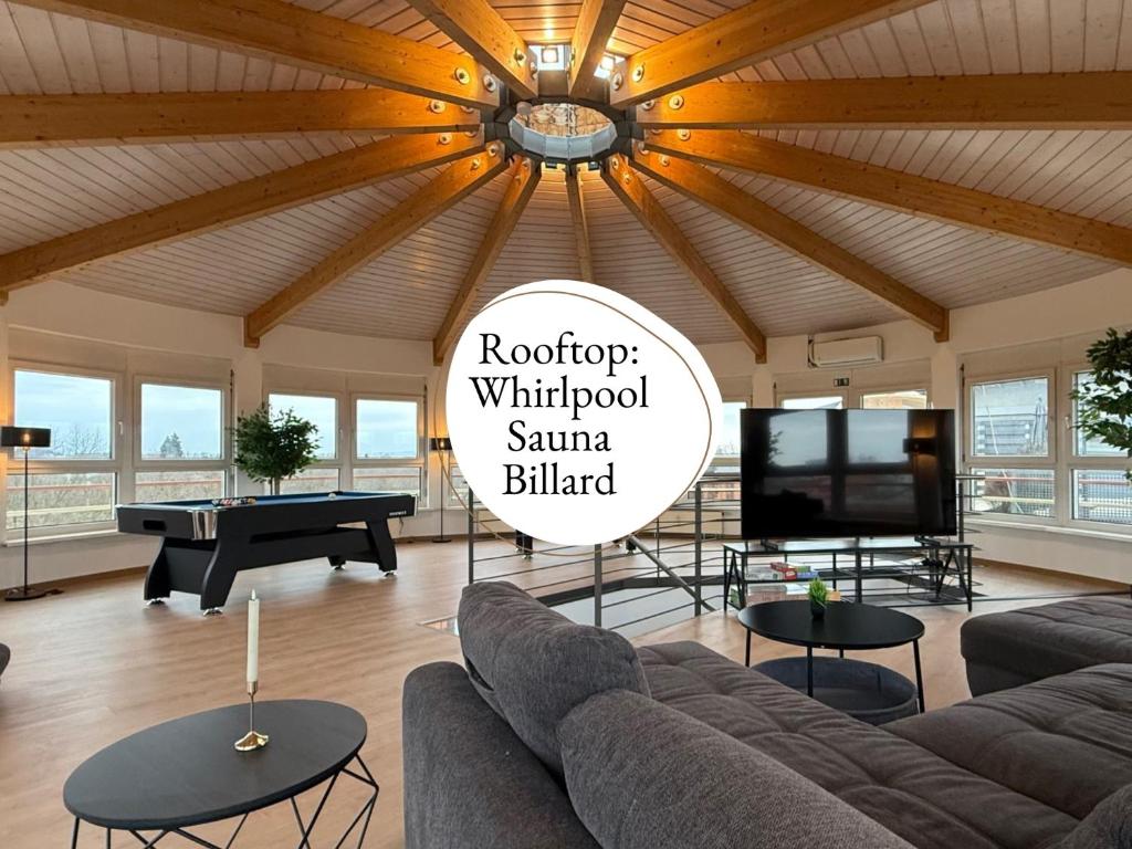 a living room with a couch and a table at Panorama Penthouse mit Dachterrasse - Sauna & Whirlpool in Karlsruhe