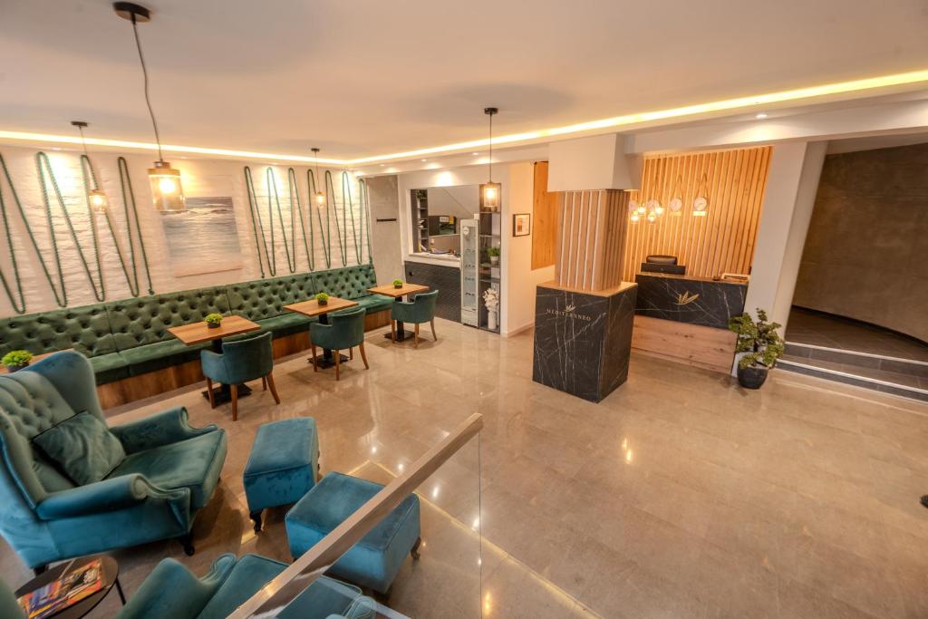 a lobby with chairs and tables in a building at Hotel Mediteraneo Garni in Novi Sad