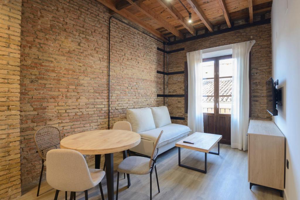 a living room with a couch and a table at Escolástica Suites Centro in Granada