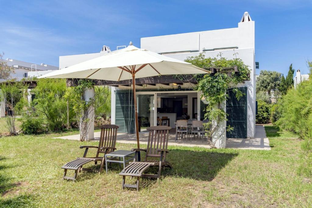 a patio with two chairs and an umbrella at Biniancolla Heura in Biniancolla