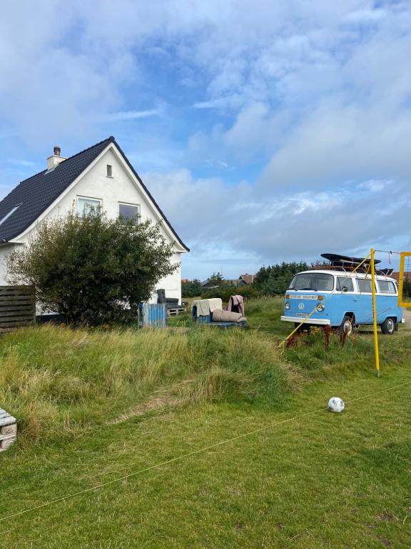 a van parked in a yard next to a house at Viking Surf House in Klitmøller