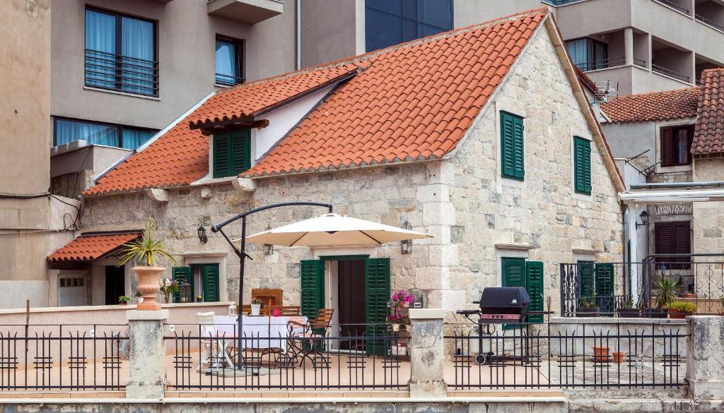 a building with a table and an umbrella at Apartments Dujam without terrace in Split