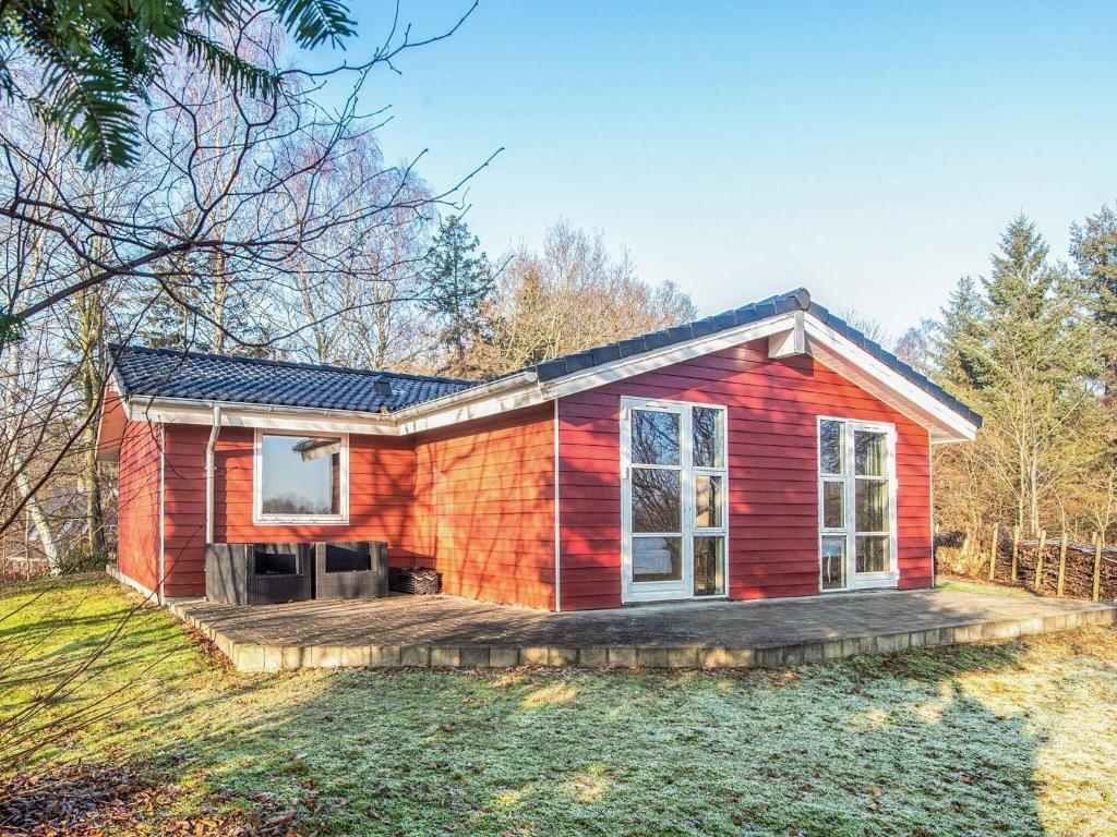 a red tiny house with a deck at 8 person holiday home in Børkop in Børkop