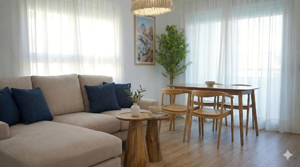 a living room with a couch and a table at Apartamentos BCL Playa Albir in Albir