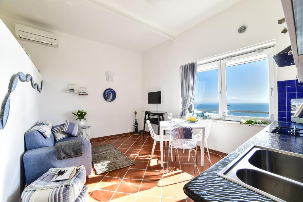 a kitchen and living room with a table and a couch at La Suite 48 in Vietri sul Mare