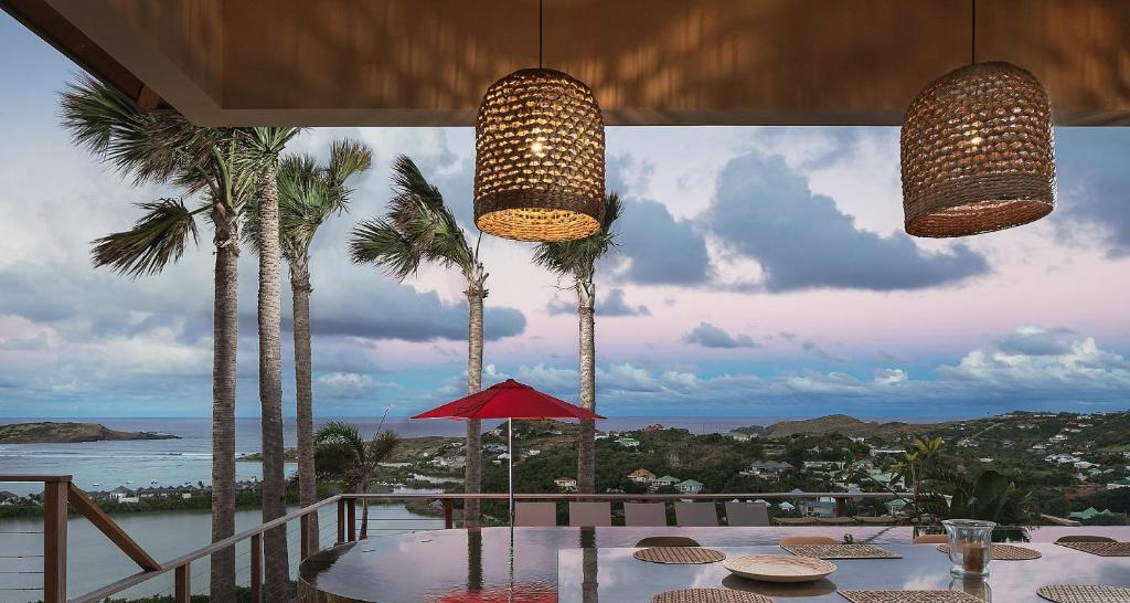 a dining room with a table and palm trees at Smart Elegant Villa with Amazing Tropical Views in Toiny