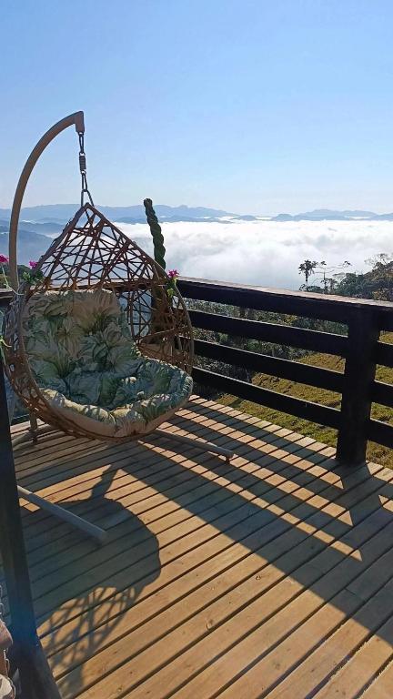 a basket sitting on a bench on a wooden deck at Chalés Refúgio nas montanhas in Guaratuba