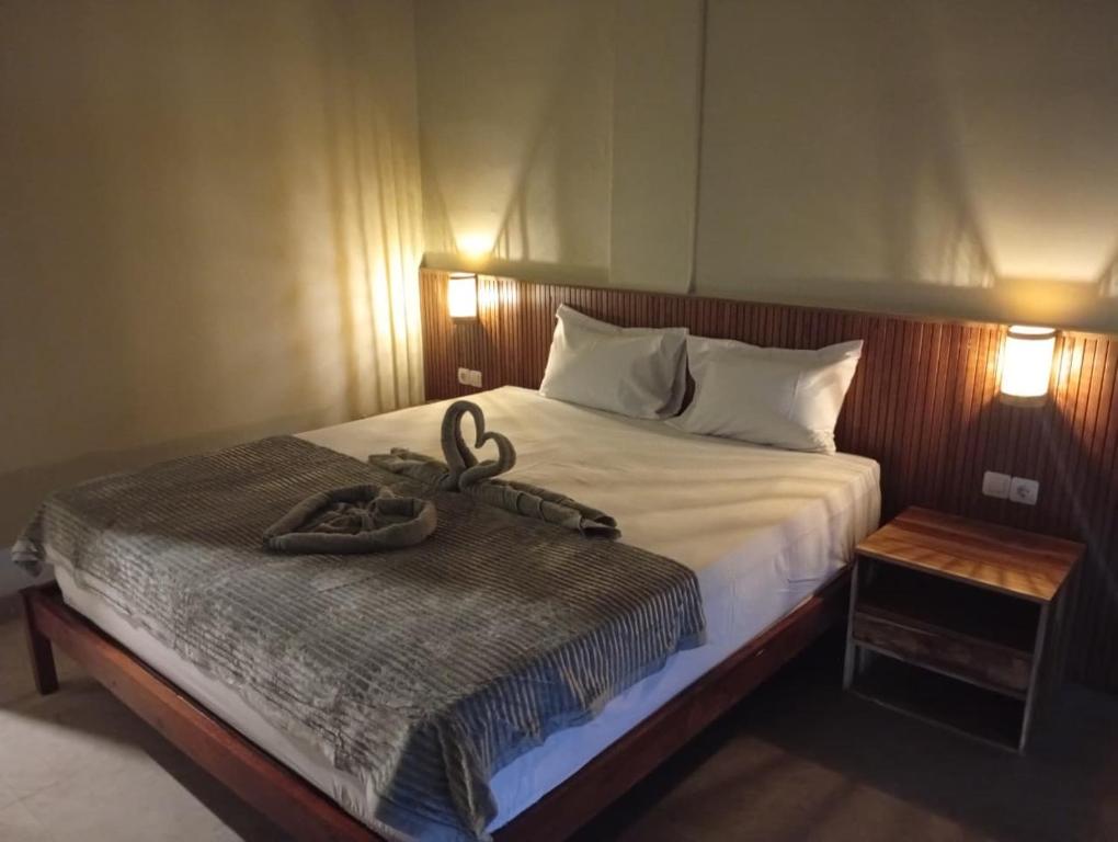 a bedroom with a bed with two snakes on it at Hepy Hotel in Kuta Lombok