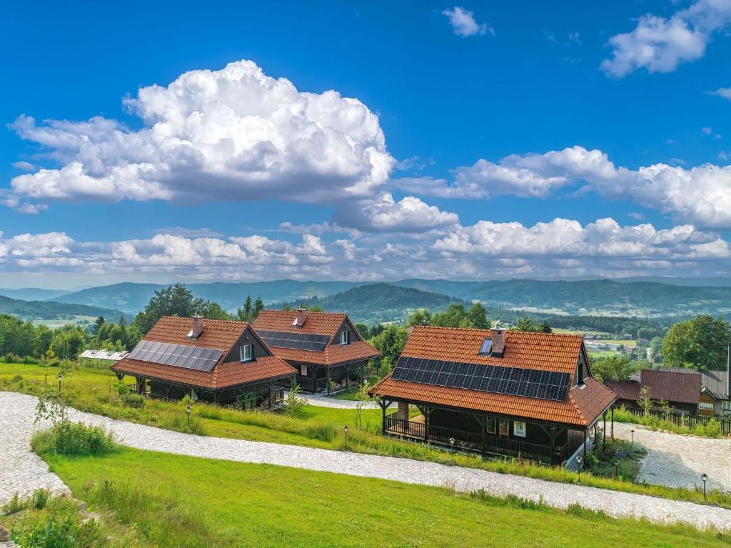 two houses with solar panels on their roofs at U Pana Boga za piecem - domki w górach, Sauna, Beskidy, Koszarawa in Korbielów