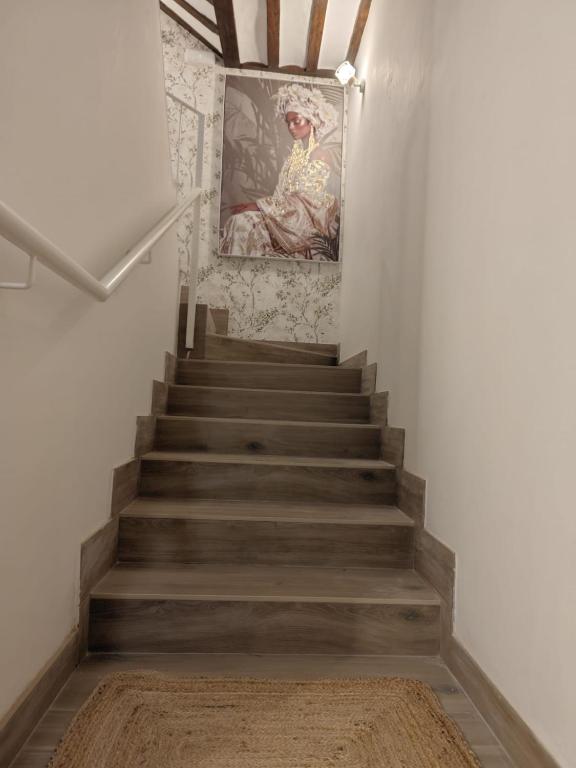 a staircase with a painting of a woman on the wall at Arturana turismo in Ollauri