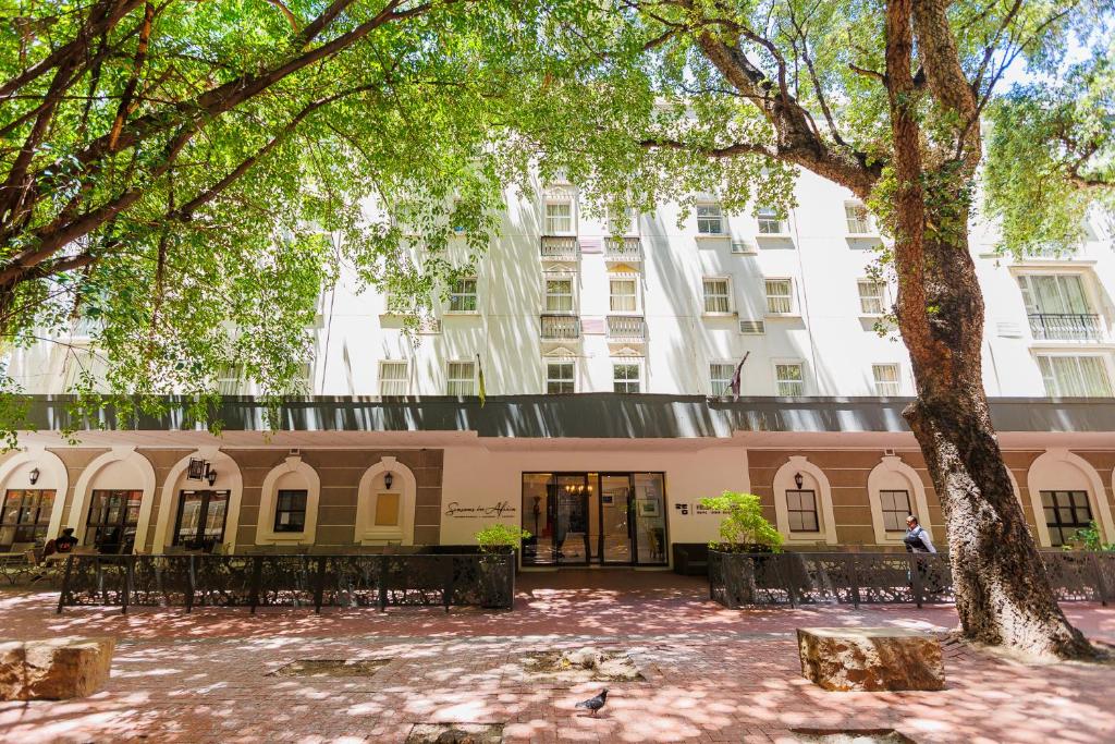 a building with a tree in front of it at 5-Min Walk to CTICC - Central & Cosy Hotel Stay in Cape Town