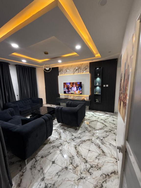 a living room with black furniture and a marble floor at Apartment 67 in Akinyele