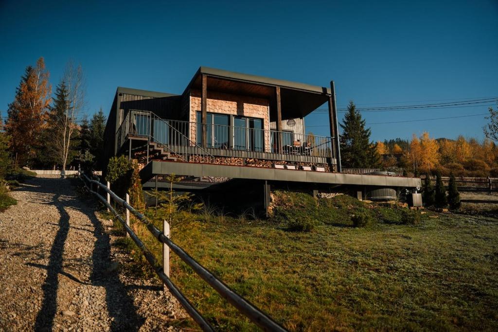 a house with a balcony and a fence at Ґонт - затишний будинок з чаном біля Буковелю in Tatariv