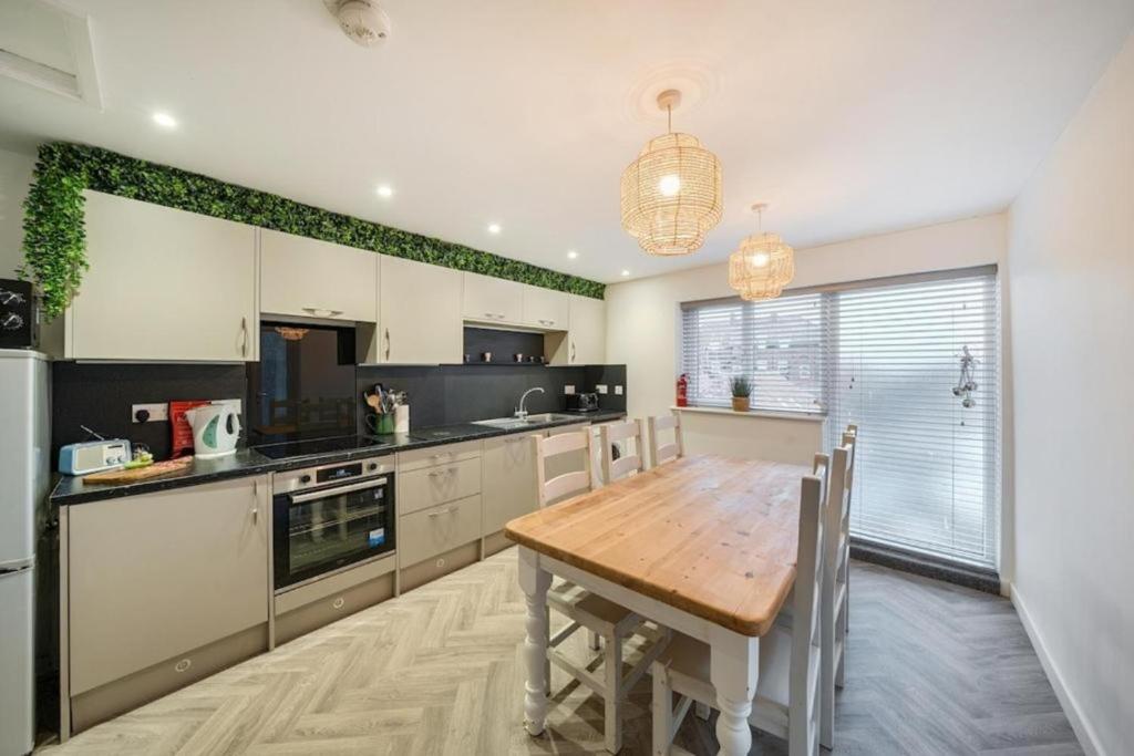 a kitchen with a wooden table and a dining room at Spacious Three Bedroom Flat in Filey Town Centre with Workspace in Filey