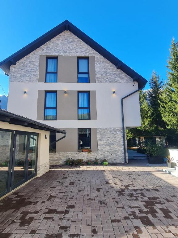 a house with a brick driveway in front of it at Solaris Zenith View in Buşteni