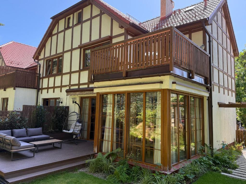 a house with a deck and a balcony at Sea You Beach House in Rogowo