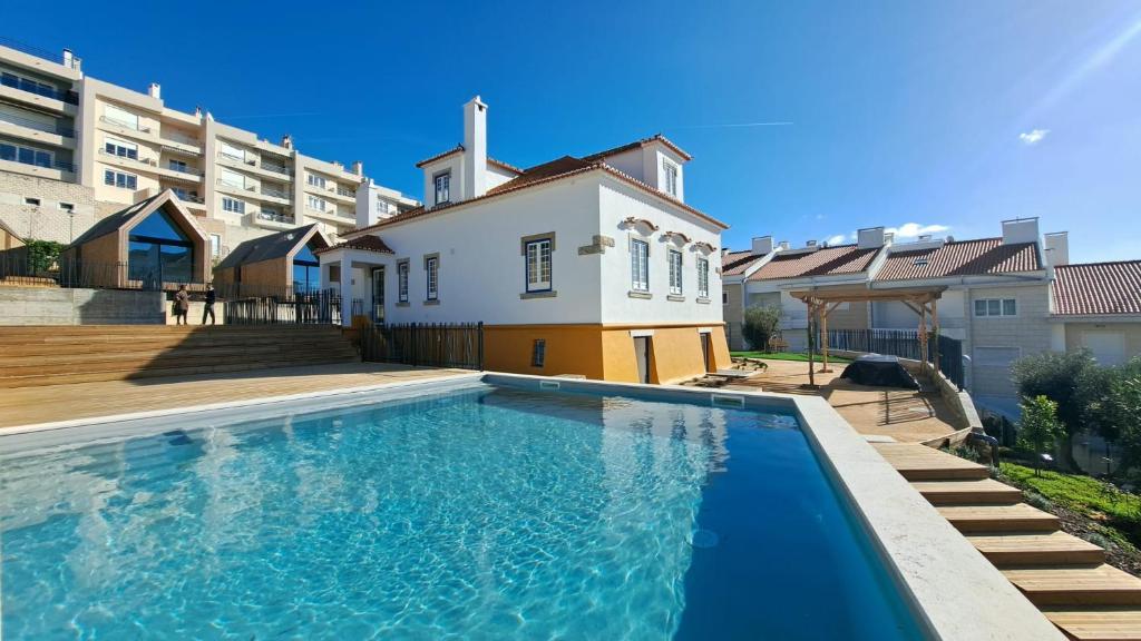 a swimming pool in front of a house at Boomerang d'O Século in Ericeira