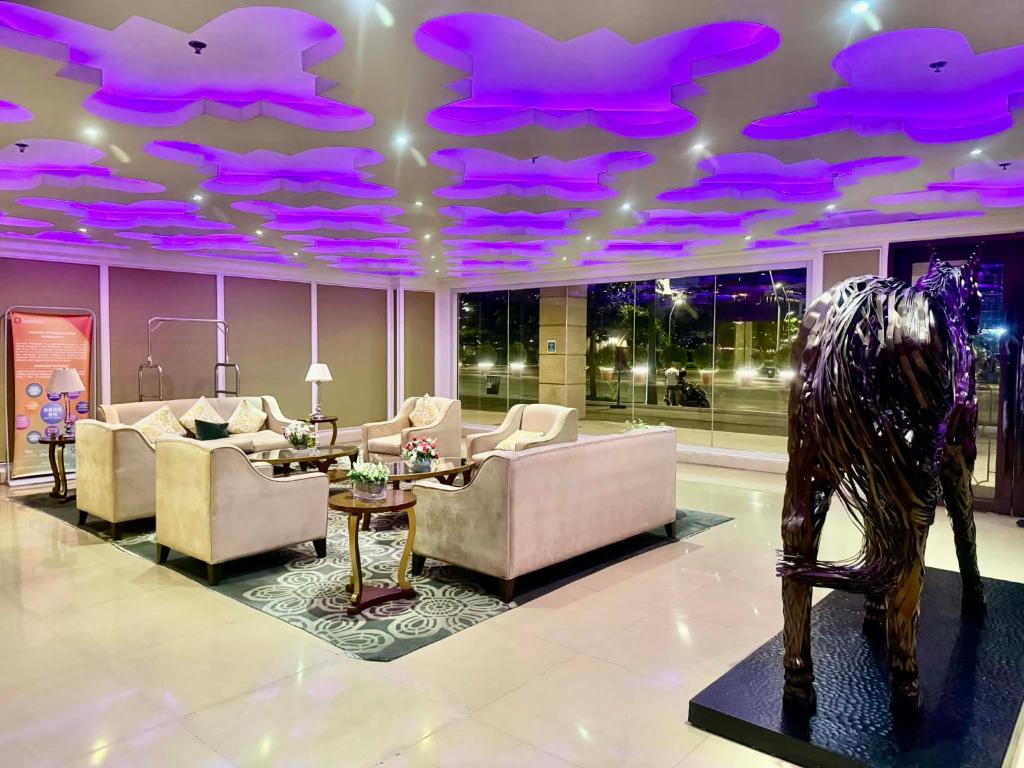 a living room with purple lights on the ceiling at Staycation near MOA at Monarch in Manila
