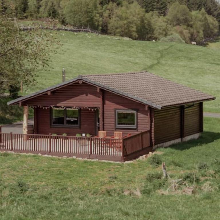 a small cabin with a fence in a field at Cateran Rest in Kirkmichael