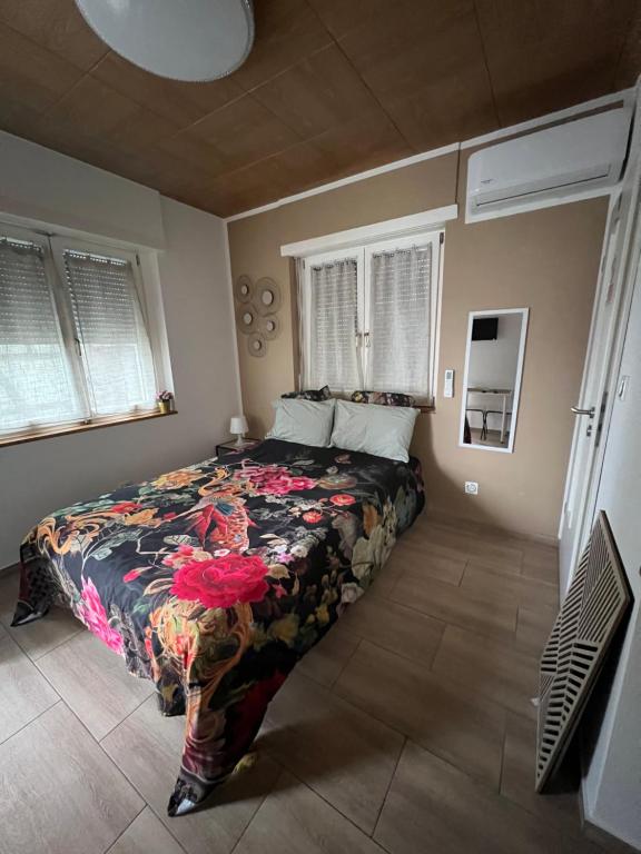 a bedroom with a bed with a floral bedspread at Maison letiluca in Hésingue
