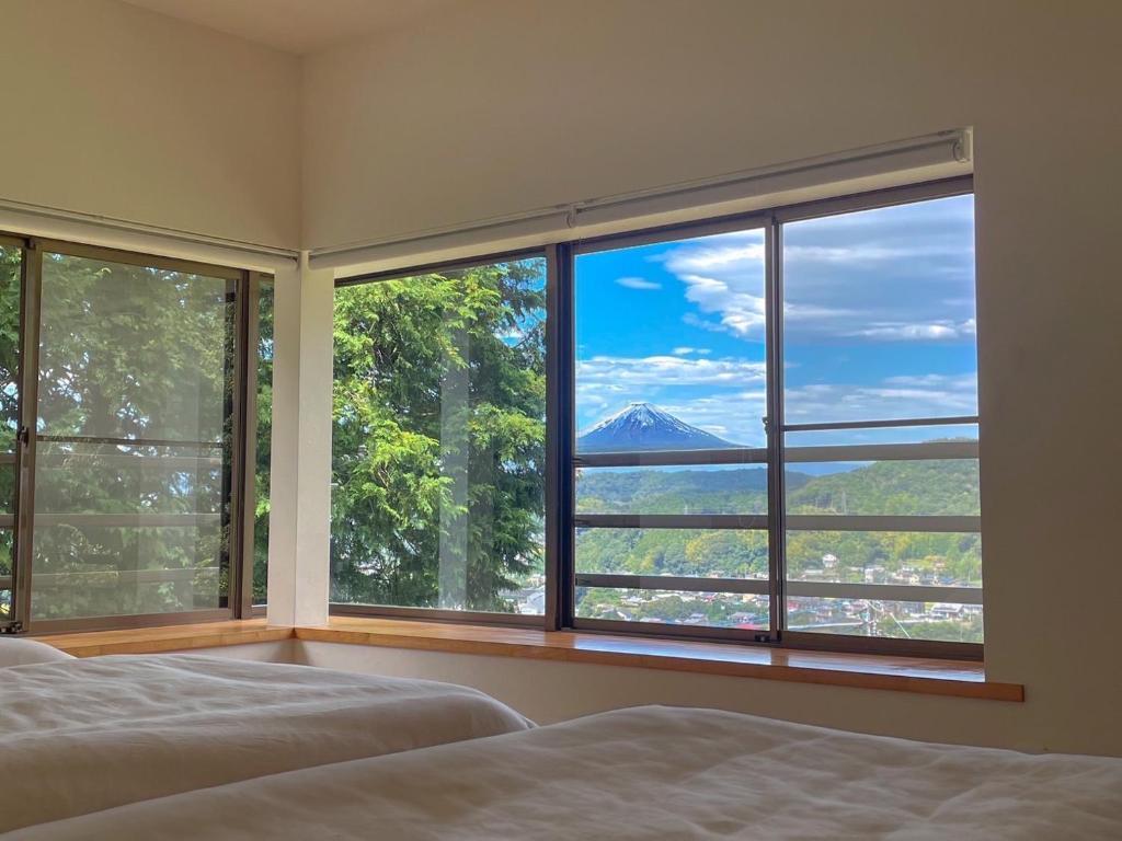 a bedroom with a view of a mountain through a window at 修善寺あざみ Luxury Japanese Villa with Mt Fuji Views and Onsen in Izu