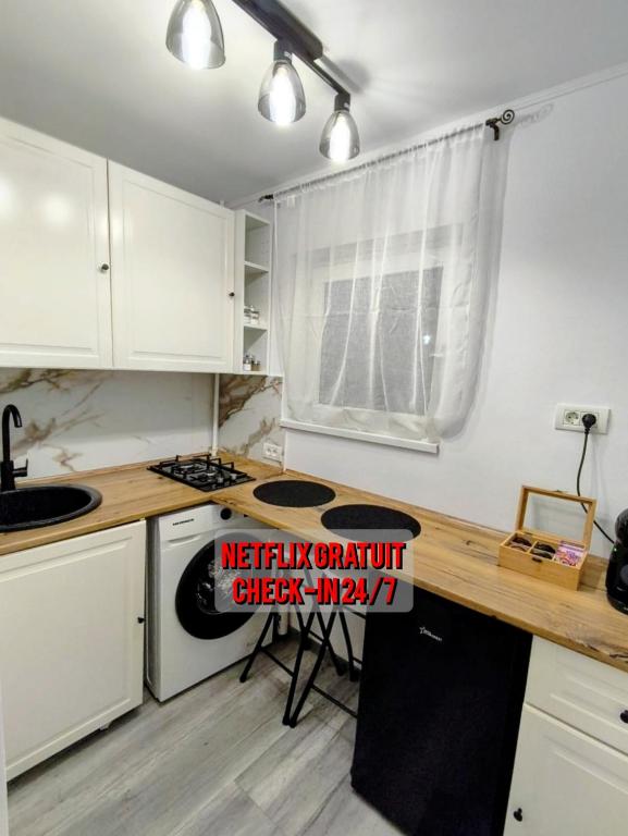 a kitchen with white cabinets and a wooden counter top at Modern Studio AFI Arad Self Check-in in Arad