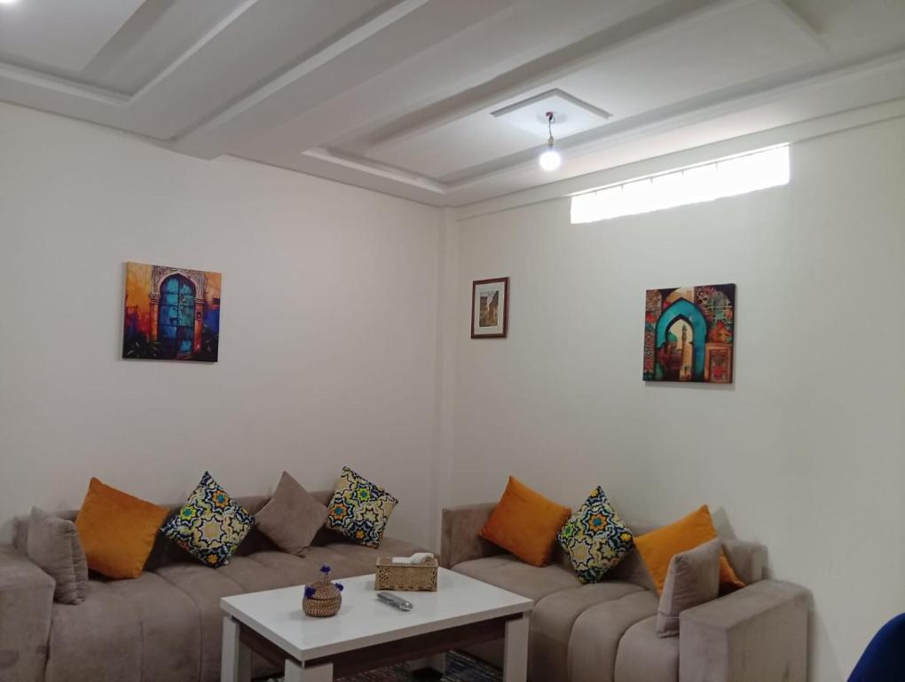 a living room with two couches and a table at Tafoukt House in Aourir
