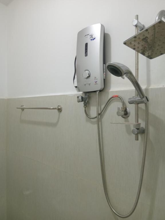 a shower in a bathroom with a soap dispenser at Jaya Rest house in Unawatuna