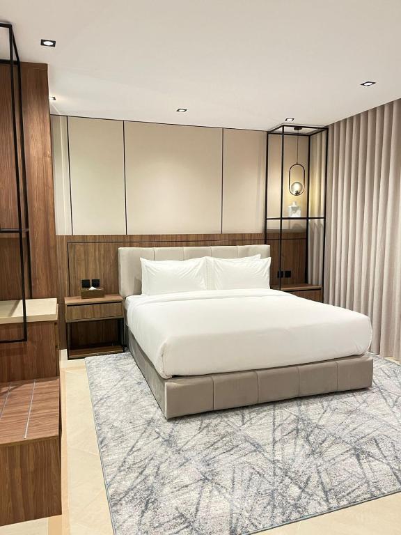 a bedroom with a large white bed and a rug at اورا بلس AURA PALACe in Taif
