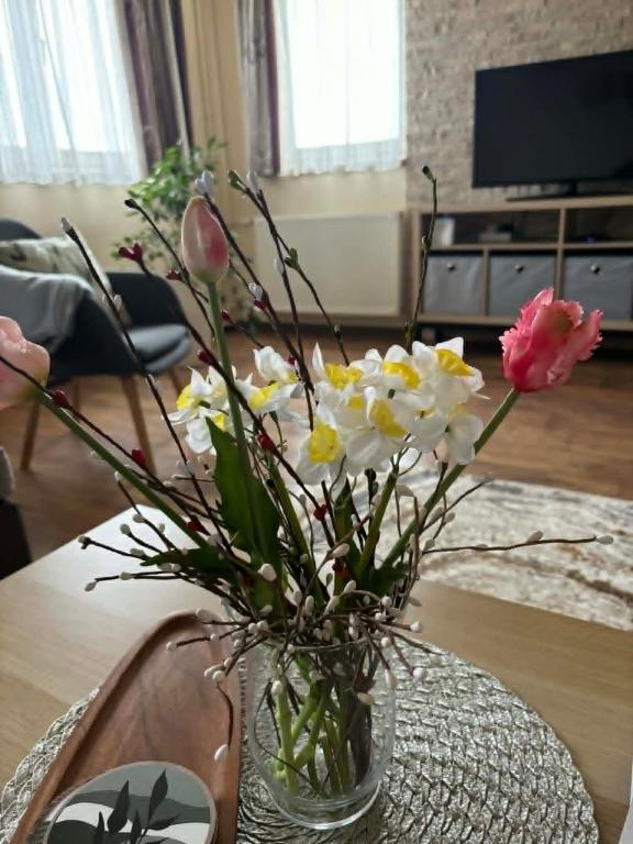 a vase filled with flowers sitting on a table at Oliver's House in Budaörs