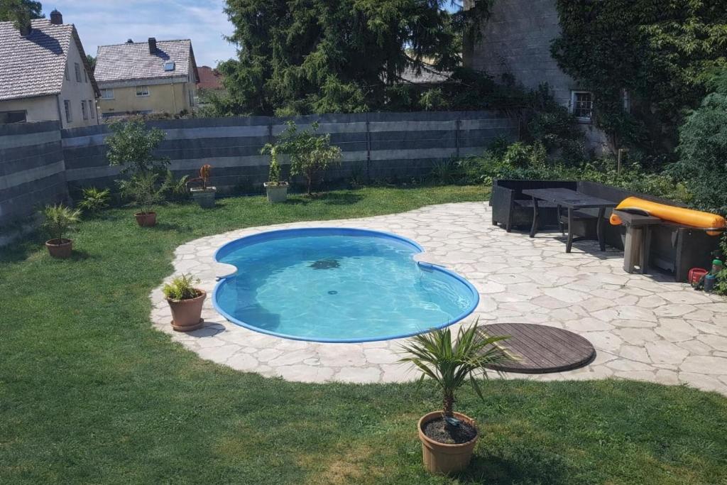 a small swimming pool in a yard with a patio at Mirko's Gästezimmer in Günthersleben