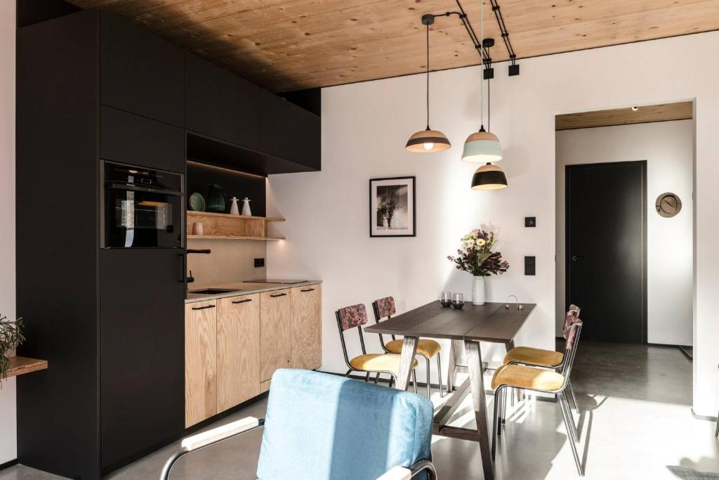 a kitchen with black cabinets and a table and chairs at Pförtner Penthouse in Hausham