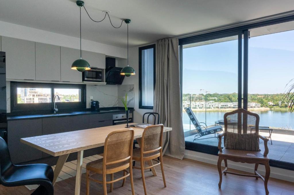 a kitchen and dining room with a table and chairs at Lake Life Exclusivo apartamento en Parque Miramar in Montevideo