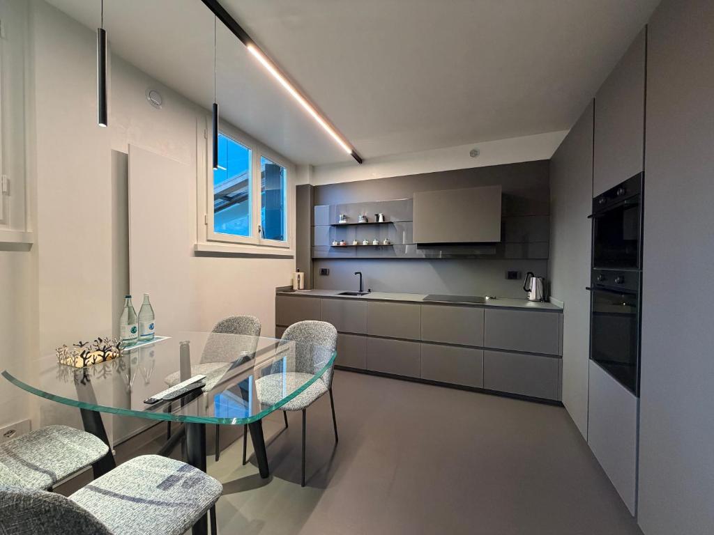 a modern kitchen with a glass table and chairs at Nuovo Fiore in Pesaro